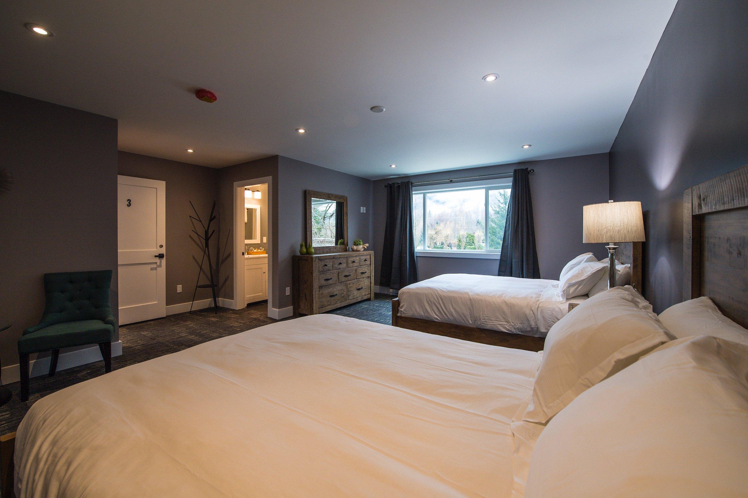 Bedroom with two large beds and grey walls