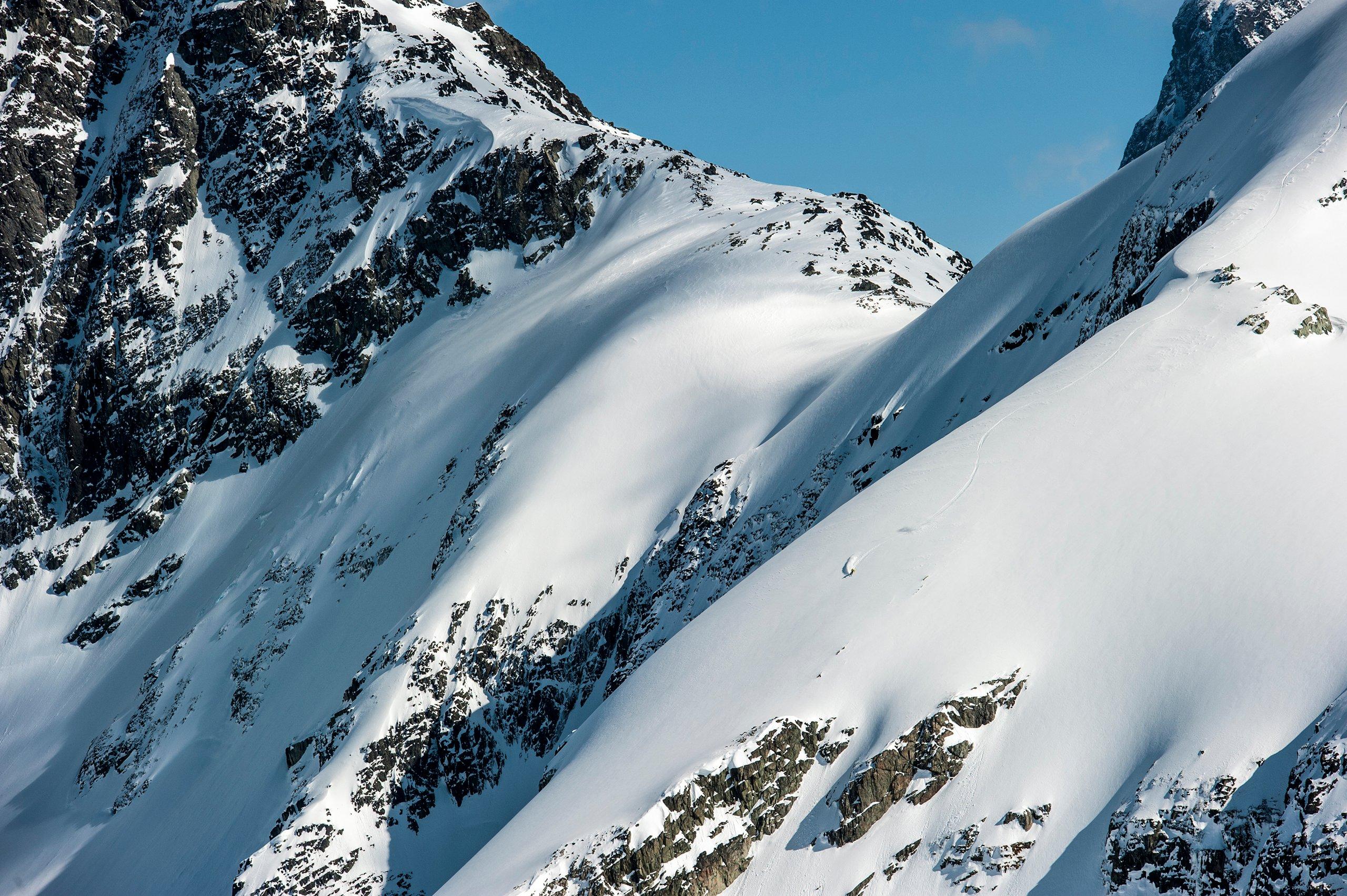 A skier descending down a snowy mountainside