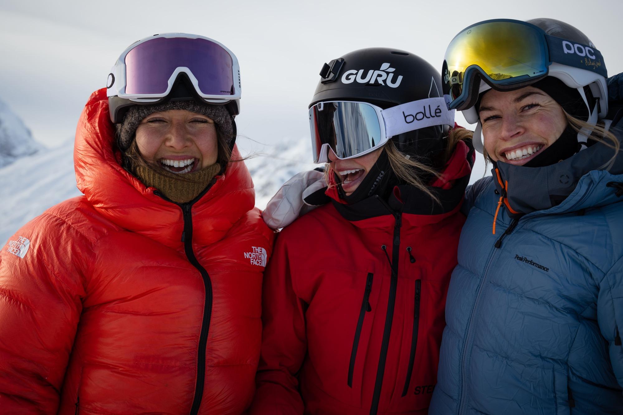 Three women in ski gear smiling and posing