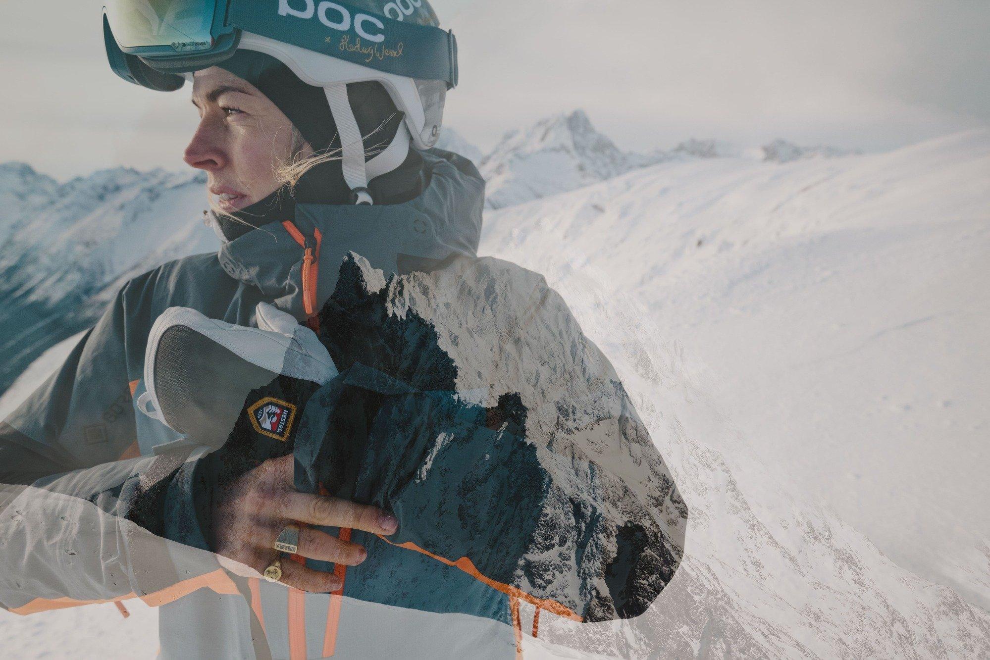 skiier holding their gloves as they look left at the mountains
