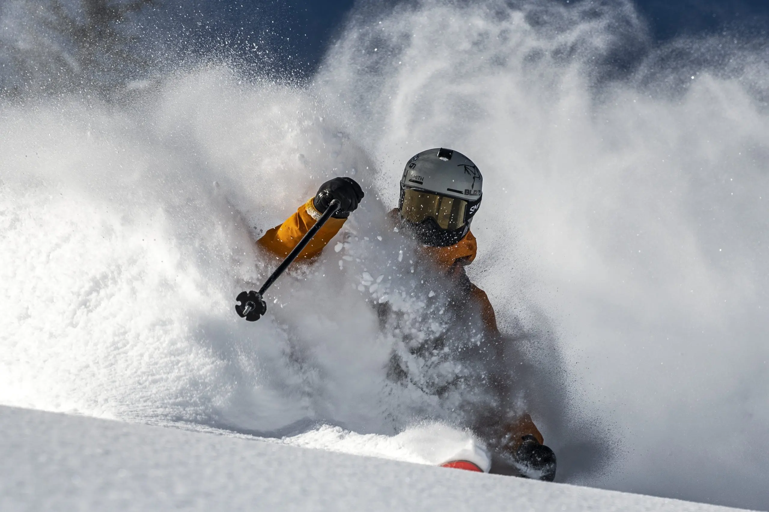a skier carving through powder as snow flies around them